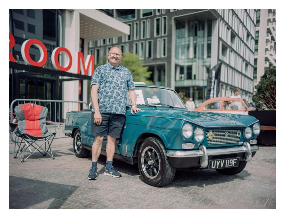 Portrait of a man in front of a classic car.