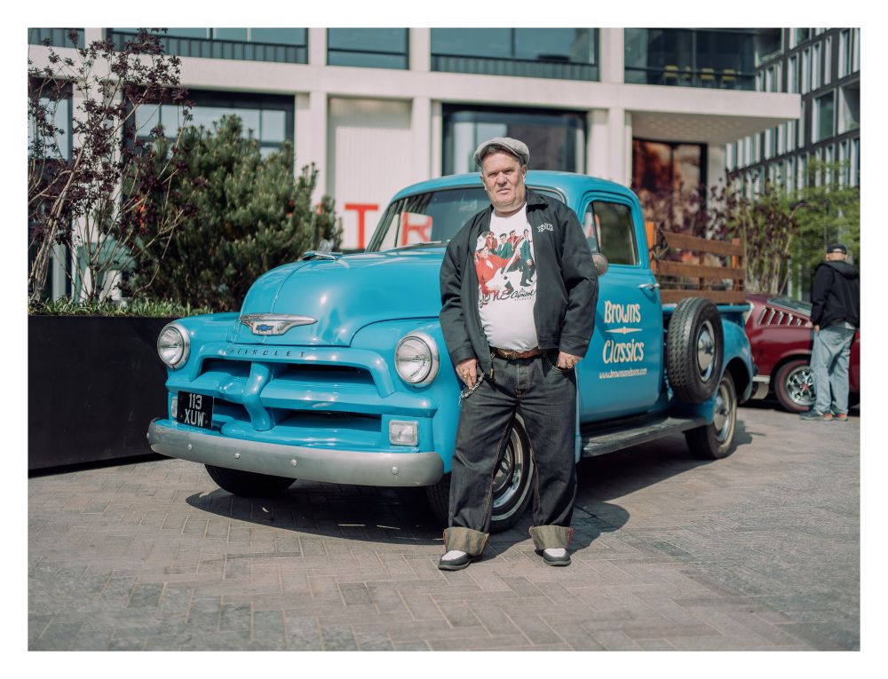 Portrait of a man in front of a classic pickup truck.