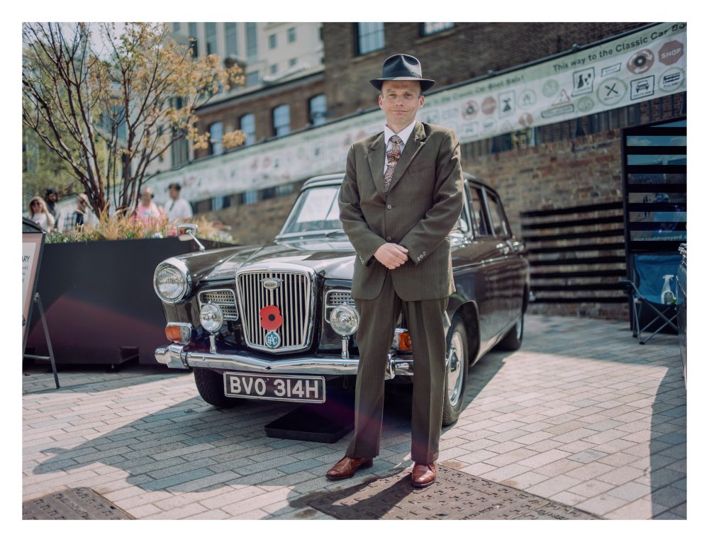 Portrait of a man in front of a classic car.
