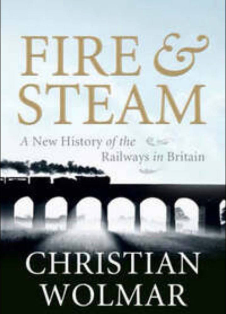 The front over of the book Fire and Steam, A new history of the Railways in Britain by Christian Wolmar - the picture is of a silhouette of a steam train going over a viaduct 