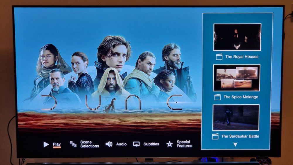 Static floating heads image with menu options at the bottom in boring white font, currently showing bonus features on the right. The thumbnails for the bonus features are animated, at least, showing a couple of seconds of footage.