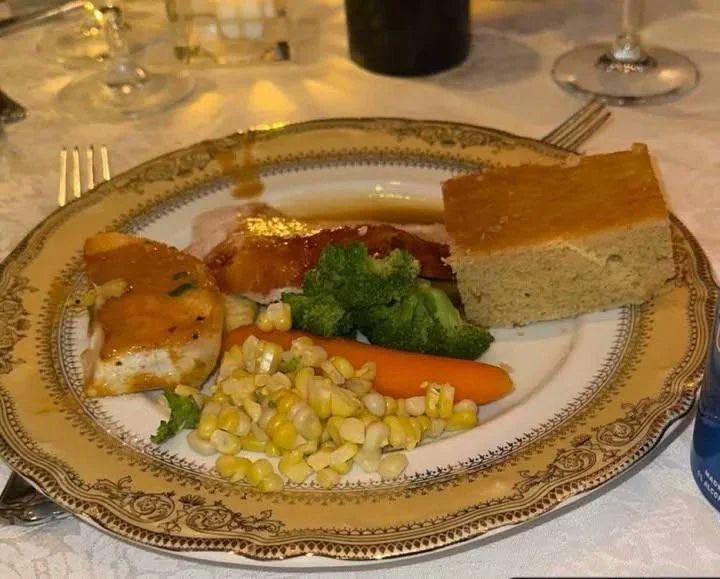 Plate of food served at Mar-a-Lago for Thanksgiving. Corn, carrot, broccoli, turkey with gravy and a square of cornbread - very unappetizing looking.