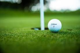 A golf ball on the edge of a golf hole