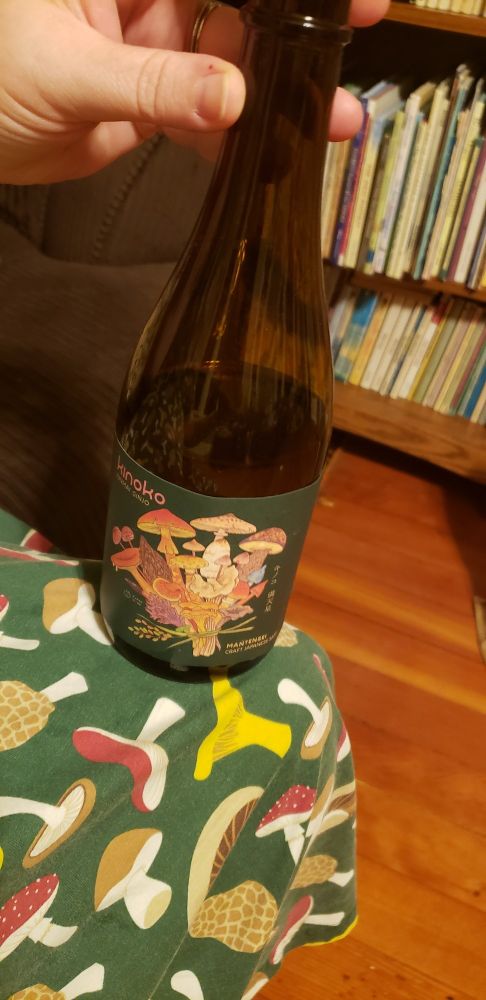 Dress with mushroom print next to sake bottle with mushrooms design on label.