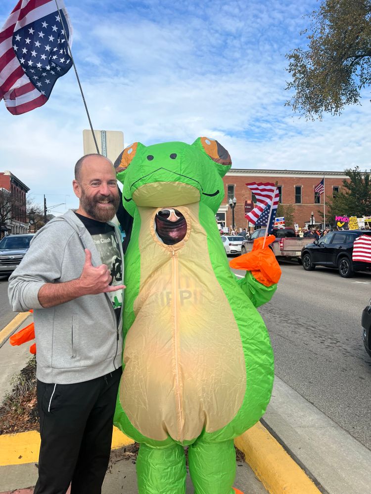Picture of me posing with the Portland frog at the No Kings protest in Howell, Mi.