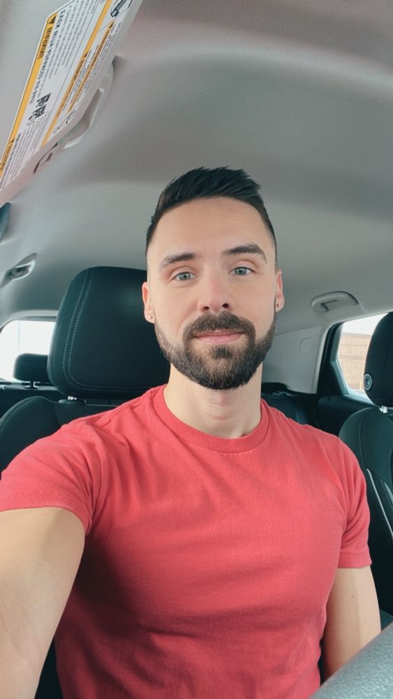 Selfie of a bearded man in the front seat of a car.