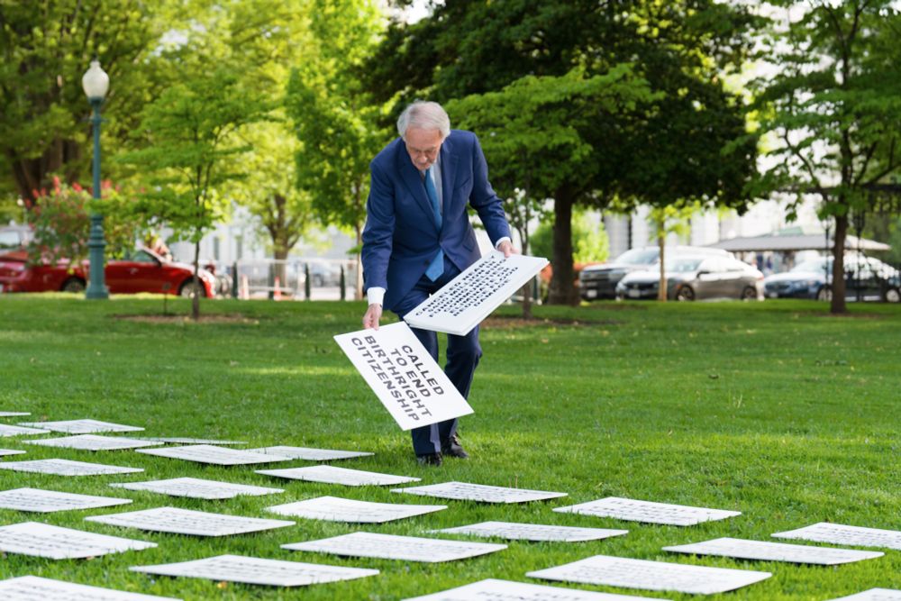 Senator Markey laying down signs on Capitol Hill lawn