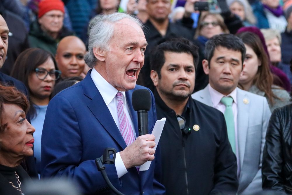 Senator Markey holds a microphone in front of a crowd