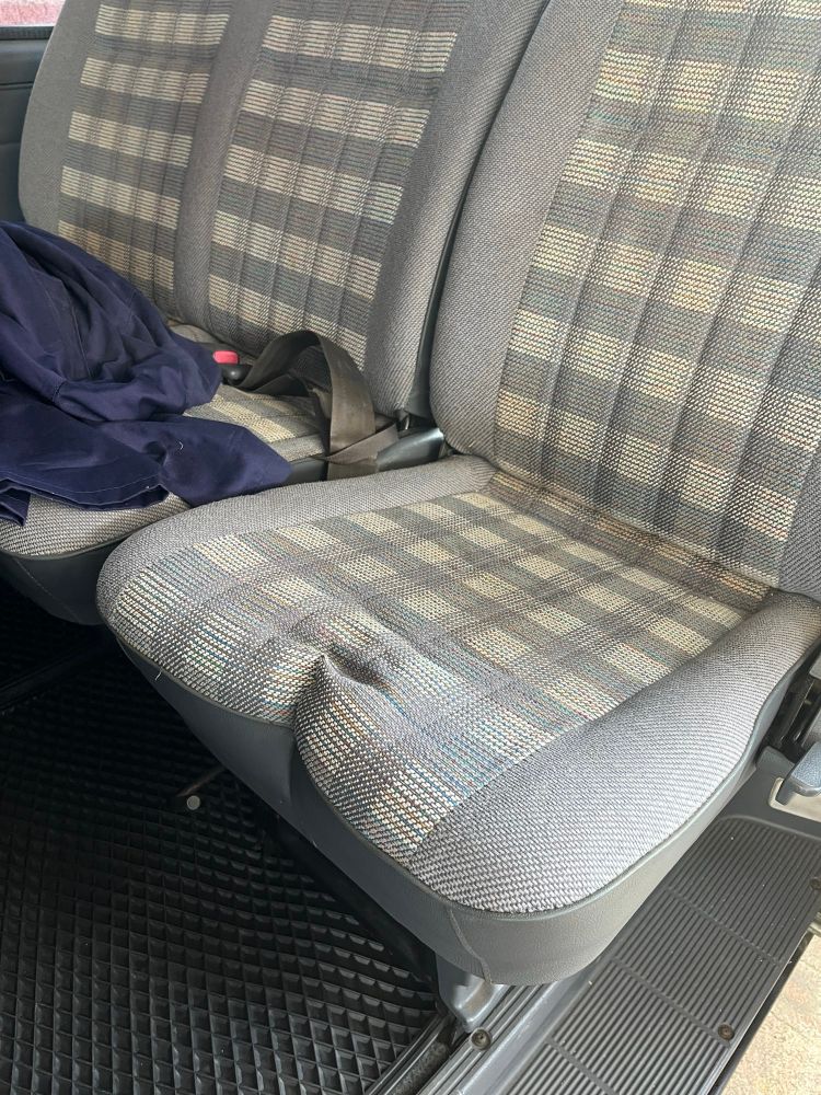 Toyota Spacia interior showing 8th seat that folds for access to the rear bench. It has developed an unfortunate crease in the middle that looks like a bum.