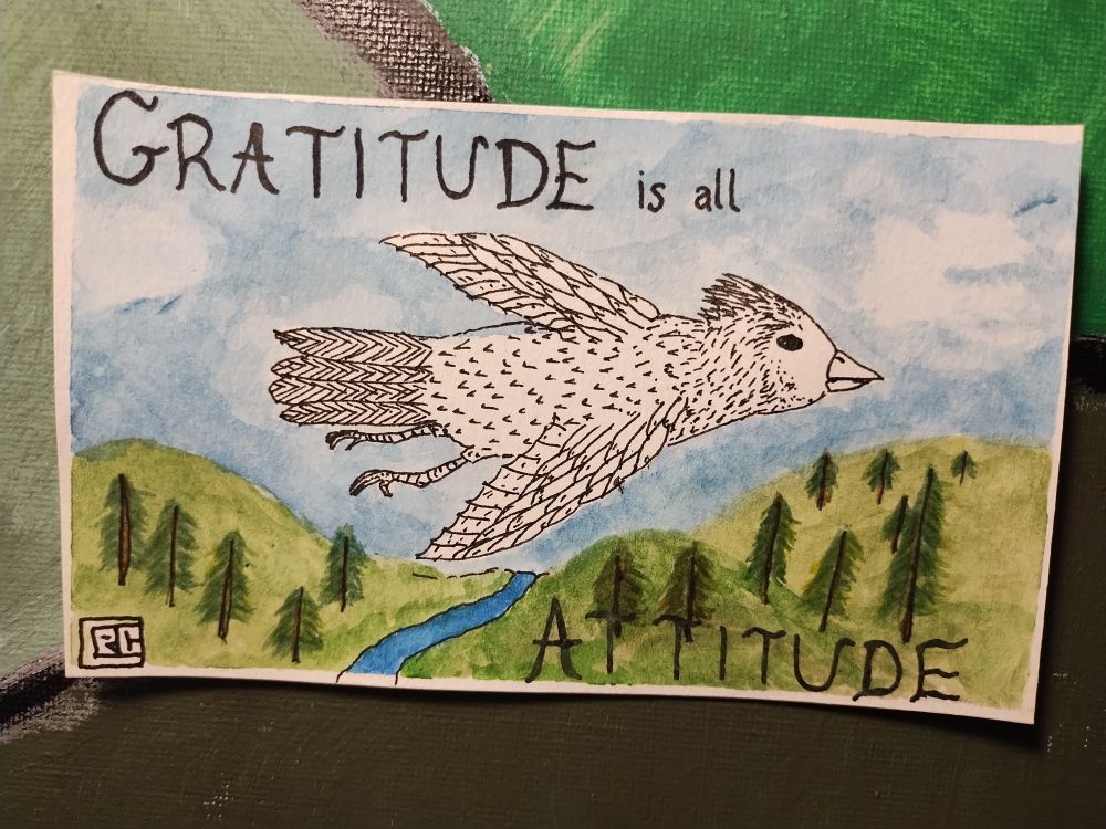 Pen and ink drawing of a bird flying over trees and hills.  Background is in color while the bird is in black and white. Text: gratitude is all attitude.