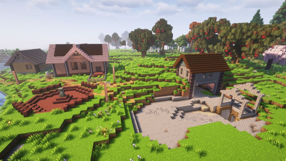 A Minecraft base, photographed from up high. To the left there is a red stone area with a waystone in the center, and 2 smaller houses behind it. To the right is the enterance to a mining area, and a small hut is carved into the hillside containing various workstations. 