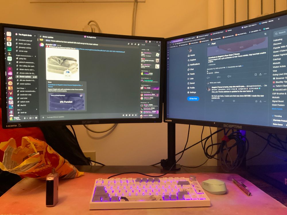 A low coffee table with 2 monitors, a pc, mouse and keyboard on it. 