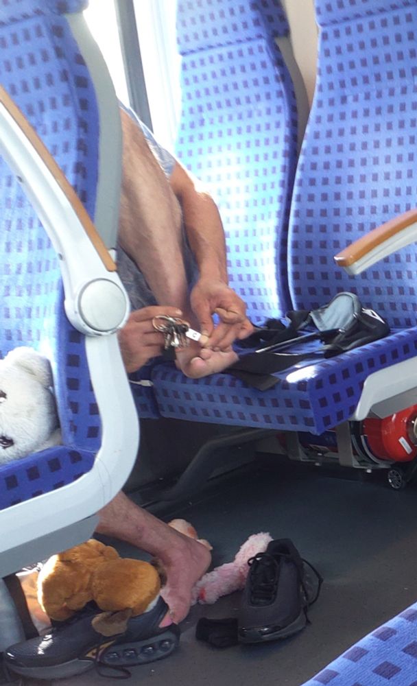 Mann kürzt sich die Zehennägel im RegionalExpress.