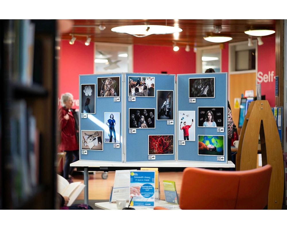 Display boards show an exhibition of photographs in a library.