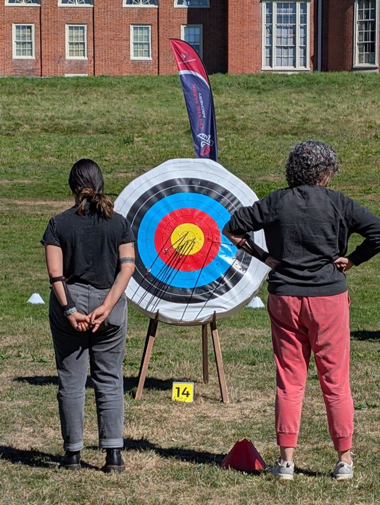My wife and her archery partner for the tournament waiting for a judge to tally their points. Nearly every arrow is in the small circle closest to the bull's eye.