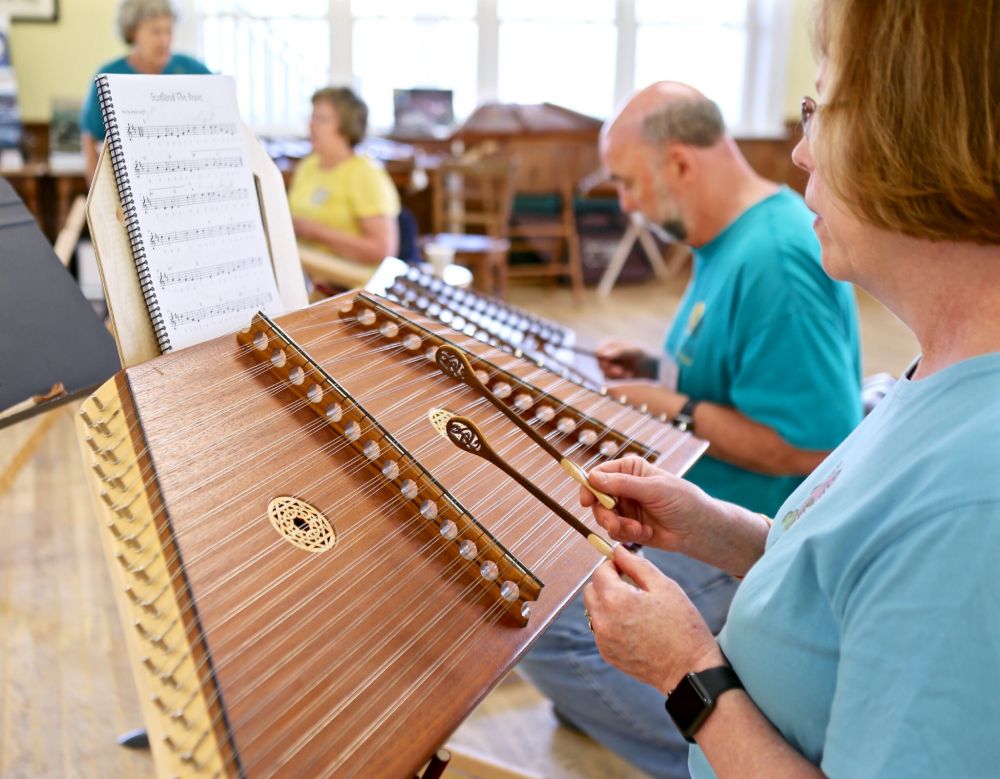 A human playing the hammered dulcimer.