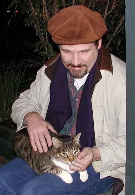 "Webster" Tabby and white cat on Bob's lap.  Outdoors at the colony location from which he was adopted.