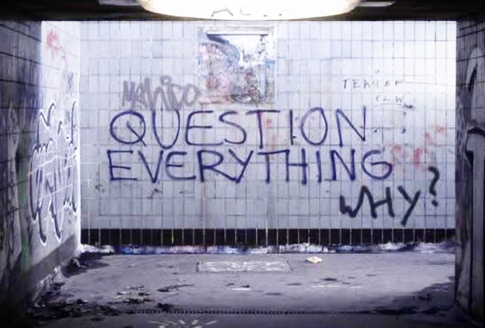 Graffiti that says “question everything” and “why”