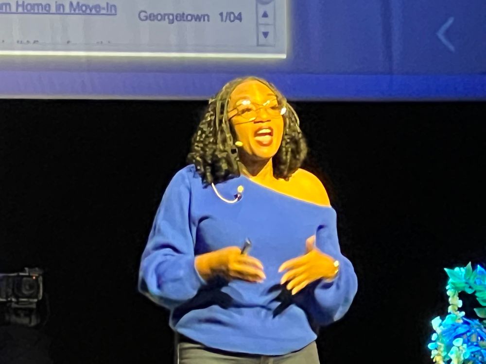 Angie speaking in a blue sweater