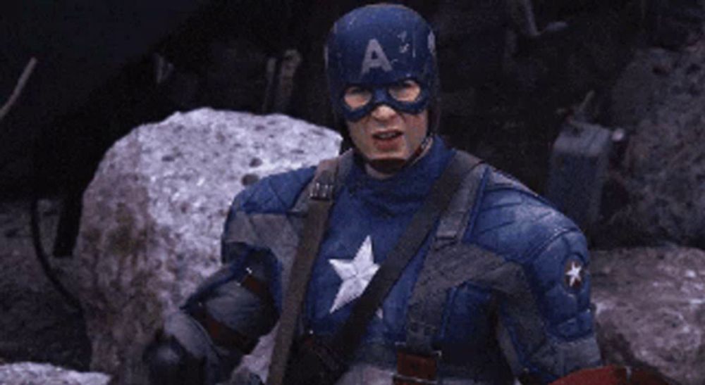 a man in a captain america costume stands in front of a rock