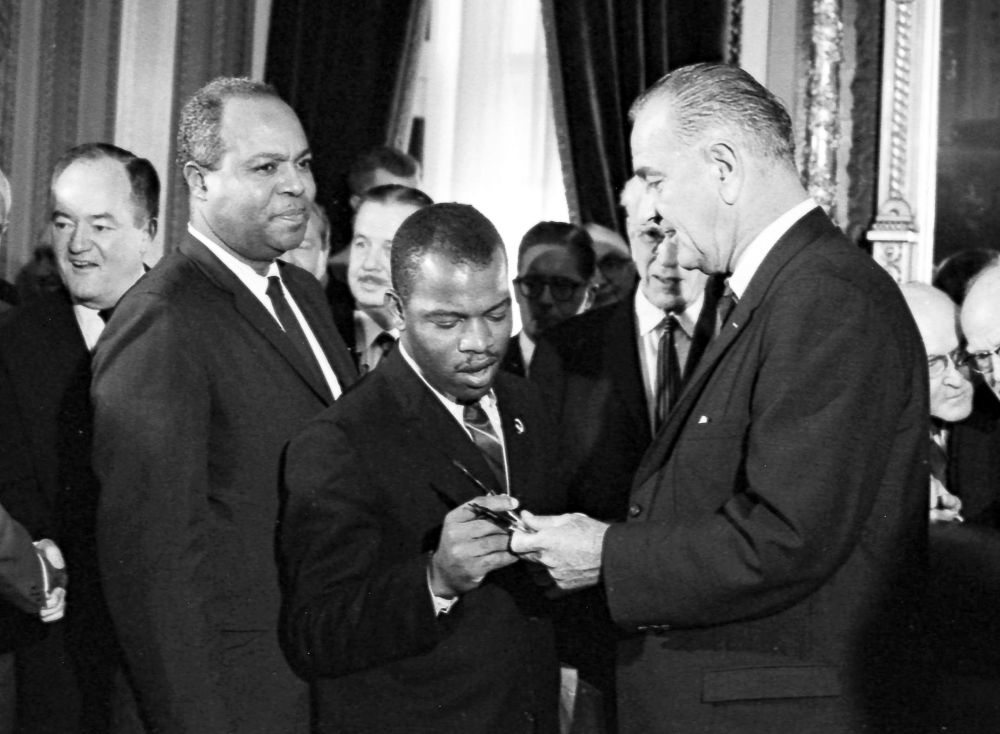 President Lyndon Johnson signs the Voting Rights Act of 1965. LBJ handing a signing pen to John Lewis.