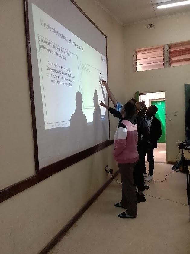 Students pointing at a projected figure, discussing the interpretation
