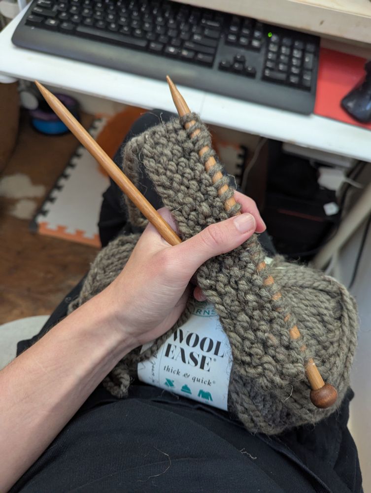 giant 9 mm bamboo needles with a few rows of stitches using super bulky grey green yarn