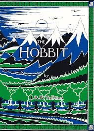 This cover of The Hobbit by J.R.R. Tolkien features an iconic design by Tolkien himself. It depicts a stylized landscape with rolling green hills, dark forests, and snow-capped mountains under a blue sky. The artwork uses bold, contrasting colors—primarily green, black, white, and blue—to create a vivid, map-like effect. The title, The Hobbit, is prominently displayed in white, and Tolkien’s name appears below it. The border has a geometric, patterned style, adding to the medieval and mythical aesthetic of the book. The design captures the adventurous spirit and fantastical setting of the story.