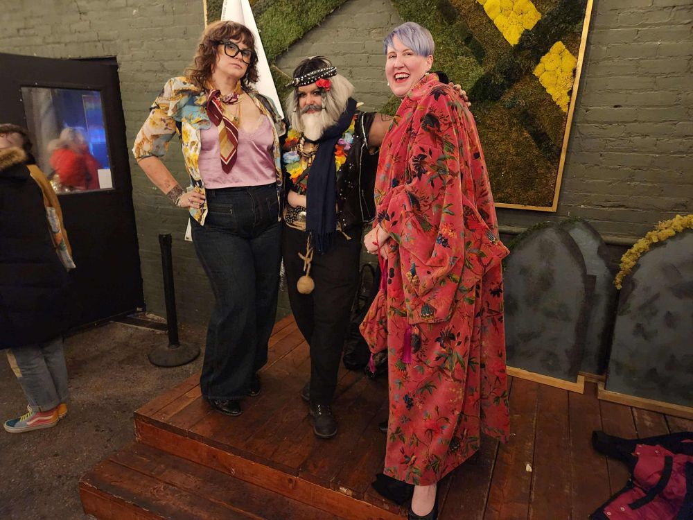 A photo of three people standing on a stage