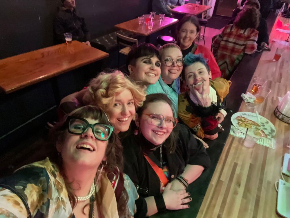 A photo of a group of people at a bar, taking a selfie.