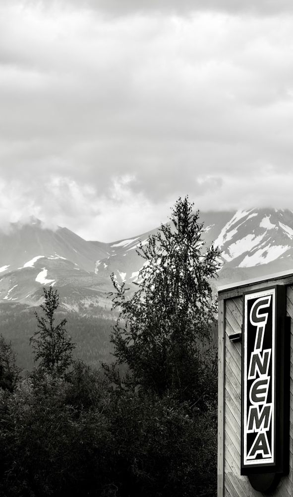Black and white photo of a cinema with Mount Shasta in the background.