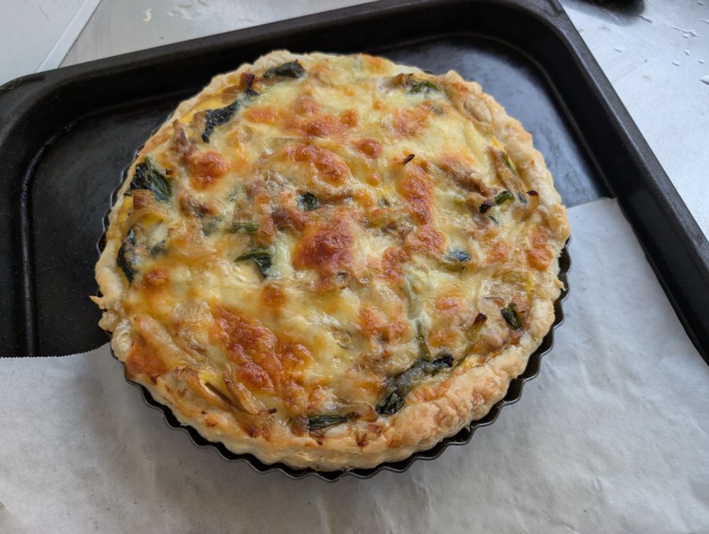 オーブンから取り出したばかりの焼きたてのキッシュ。ツナ缶と玉ねぎとほうれん草としいたけを具材に使ったが、表面のチーズであまりよく見えない。