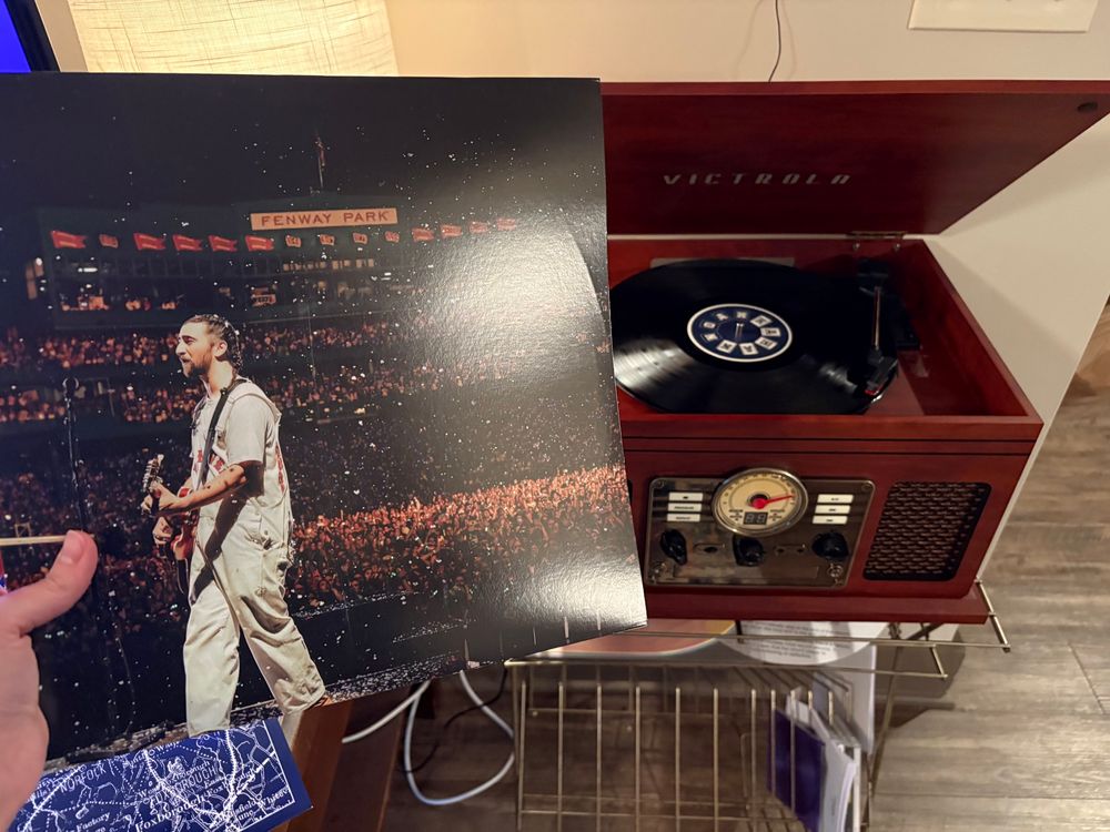 Picture of Noah Kahan Live from Fenway vinyl case and record on a player
