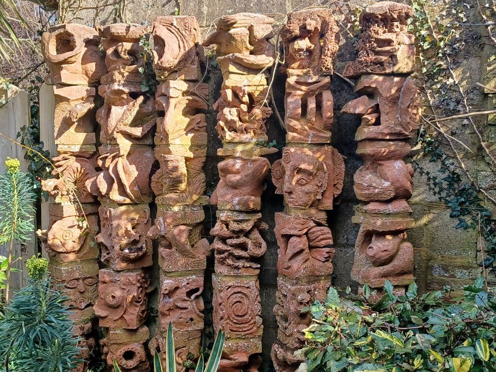 Columns of stones in different shapes. Includes fish and faces.