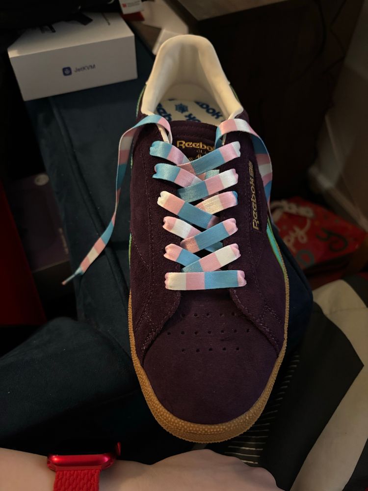 Purple Reebok leather shoes with tan soles, the shoe laces are the trans pride flag, blue pink white in color