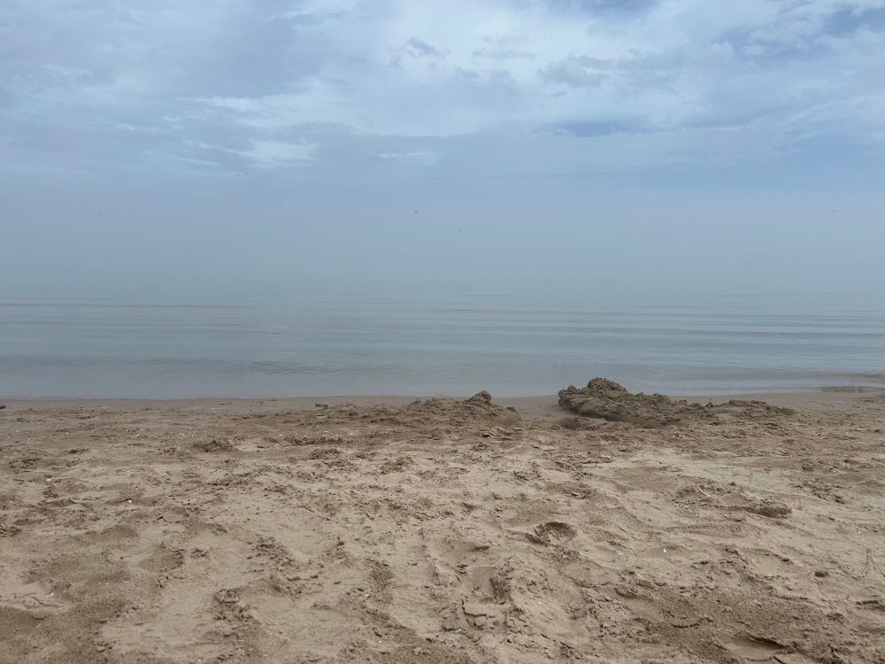 Lake Michigan in Wisconsin with sand taking up half of the frame - fog on the horizon