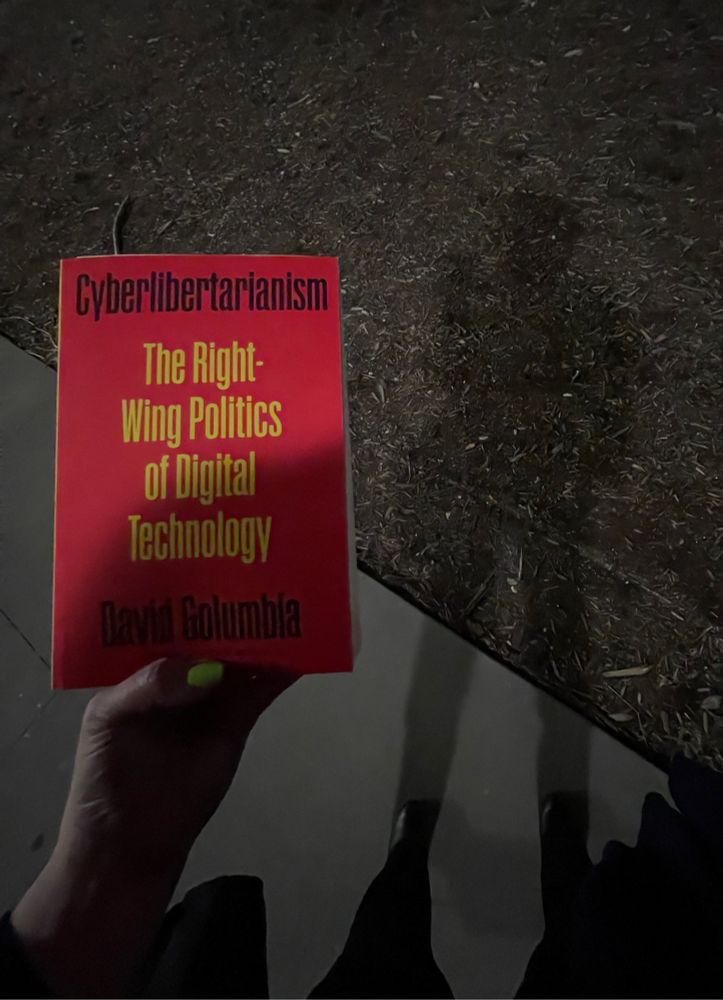 Cyberlibertarianism
The Right Wing Politics of Digital Technology by David Golumbia. Photograph of the bright pink book cover in the dark outside, next to my shadow on the ground.