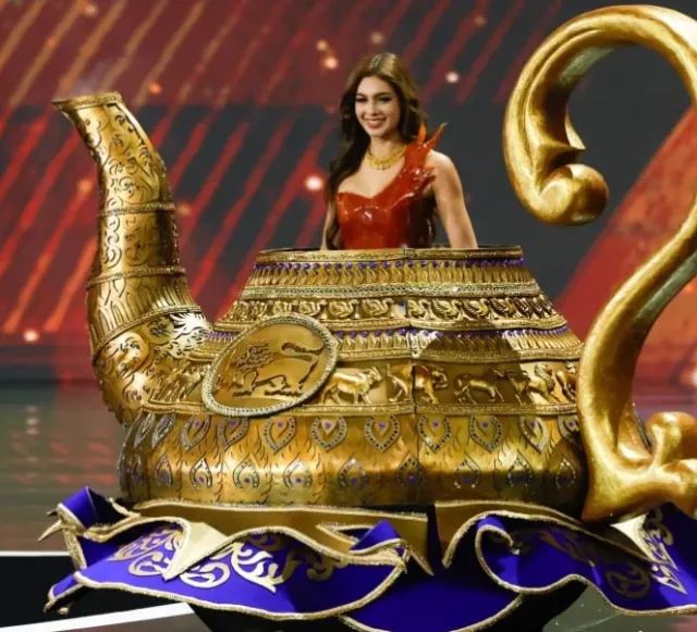 Miss Sri Lanka on stage wearing a giant gold teapot dress 