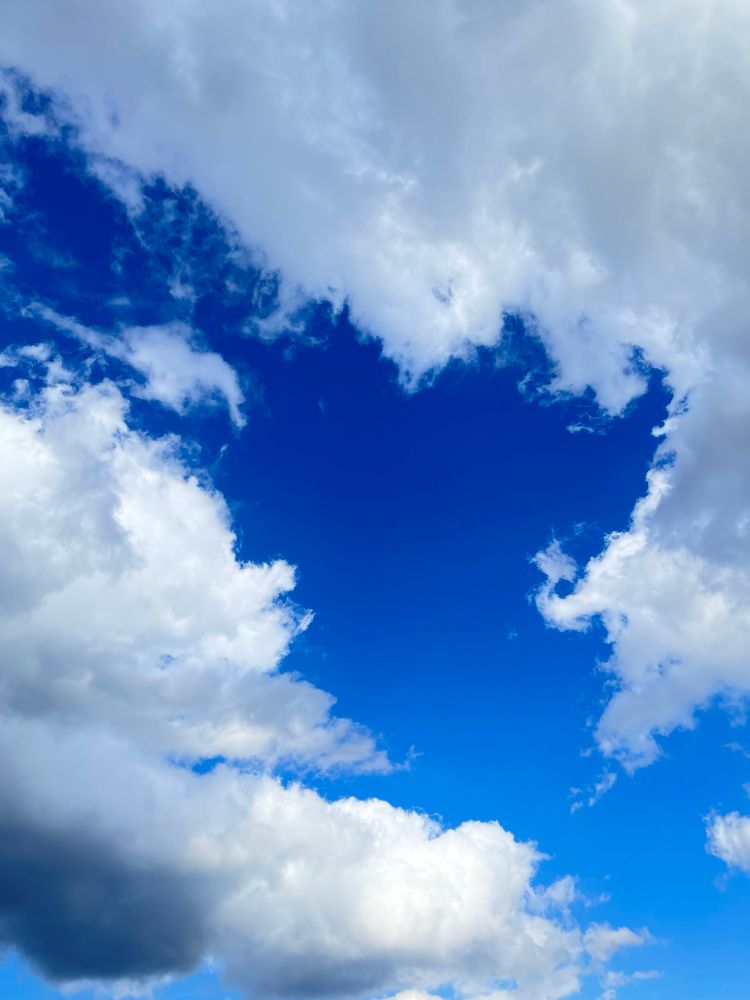Puffy white clouds in deep blue sky.