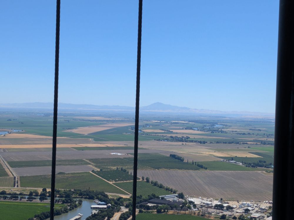 View from a tall broadcast tower. Mt. Diablo peeks out on the skyline. The view is broken a little by the elevator cable loops coming down the other side of the tower