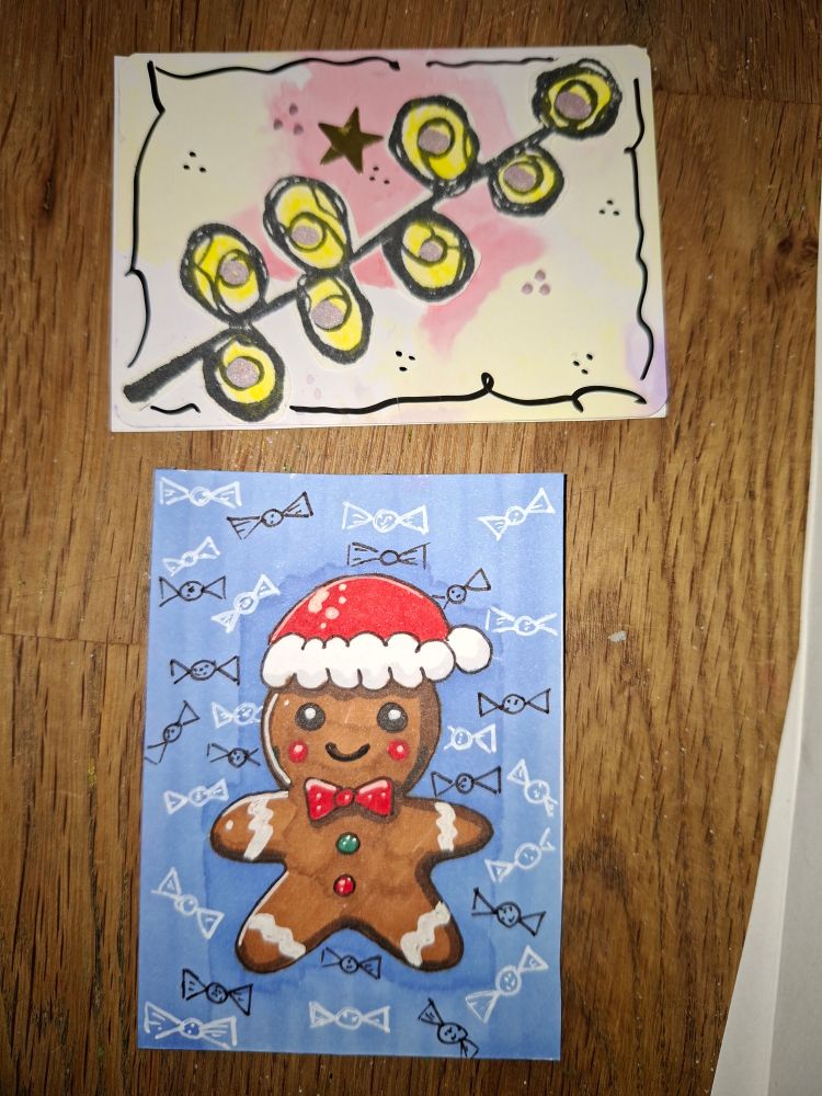 Stab schwarz, gelb, goldenen Bällen links und rechts (ähnlich einem unpaarig gefiederten Blatt); Hintergrund gelb/rosa mit schwarzem Rahmen.
Lebkuchenschneemann mit roter Zipfelmütze
Hintergrund blau mit weißen und schwarzen Bonbons/Schleifen