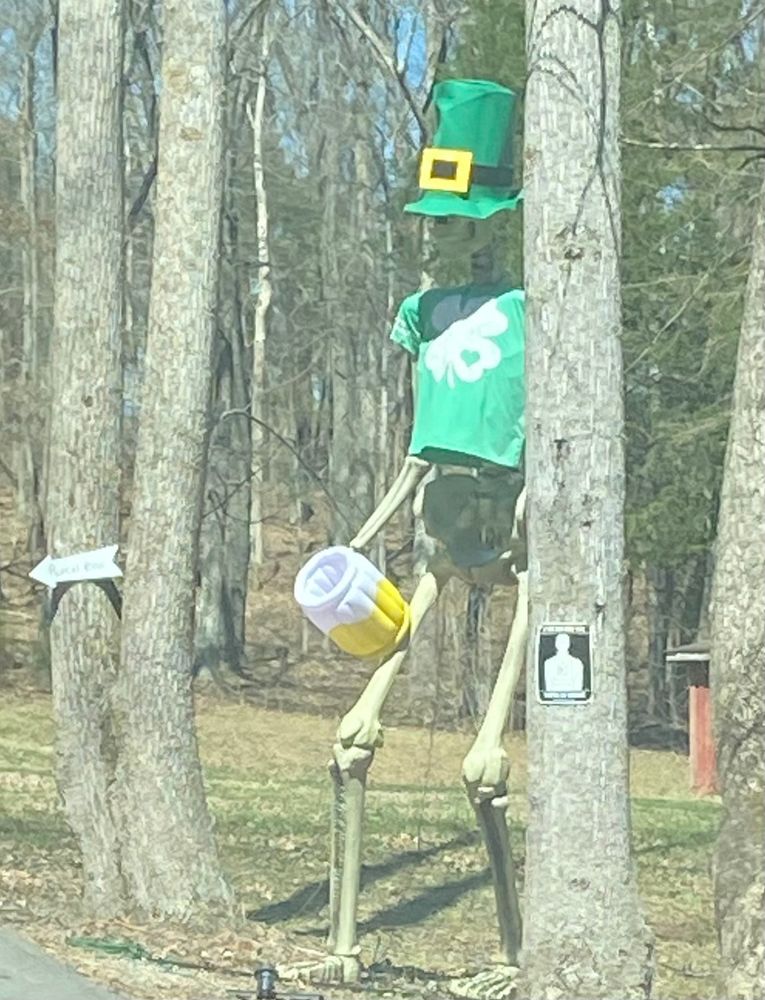 festive st patty’s skeleton drinking a blow up beer. party on brother