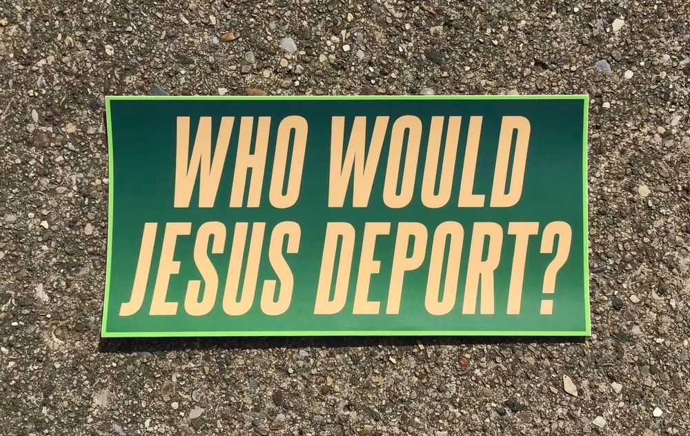 A photo of a bumper sticker. The sticker has a lime green border and a gradient green background. The text is yellow and asks ‘Who Would Jesus Deport?’