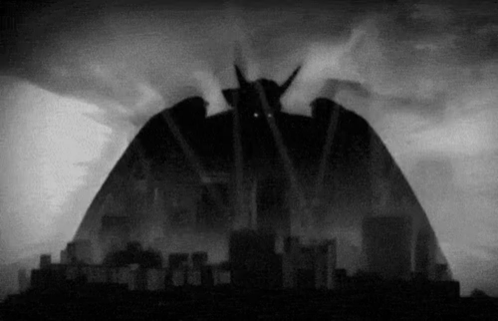 a black and white photo of a monster coming out of the sky over a city