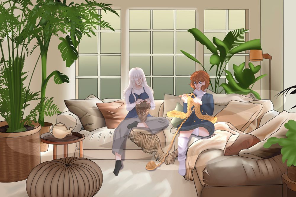 Two woman crotchet on a large couch filled with blankets and pillows. There are large ferns in the room, as a well as a teapot on a nearby table. It is early Morning. 
