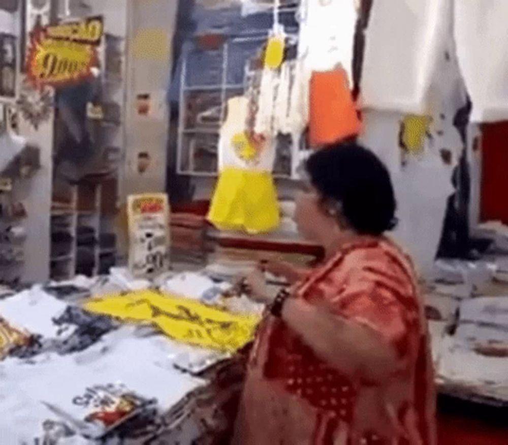 a woman is standing in front of a table in a store .