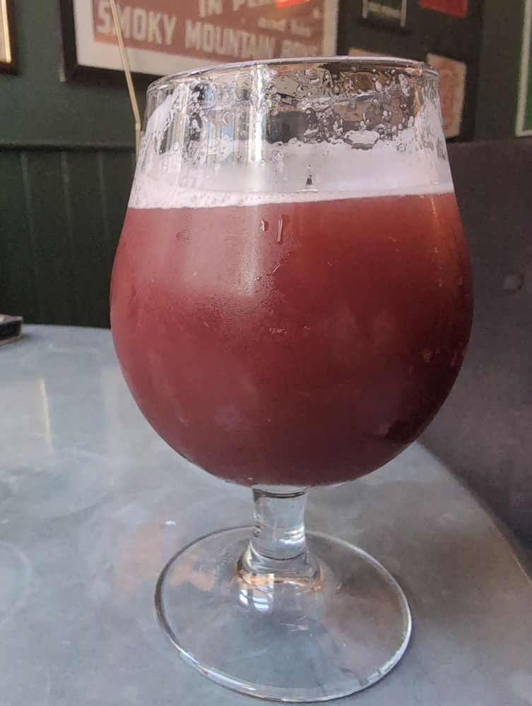 A burgundy colour sour beer in a snifter glass