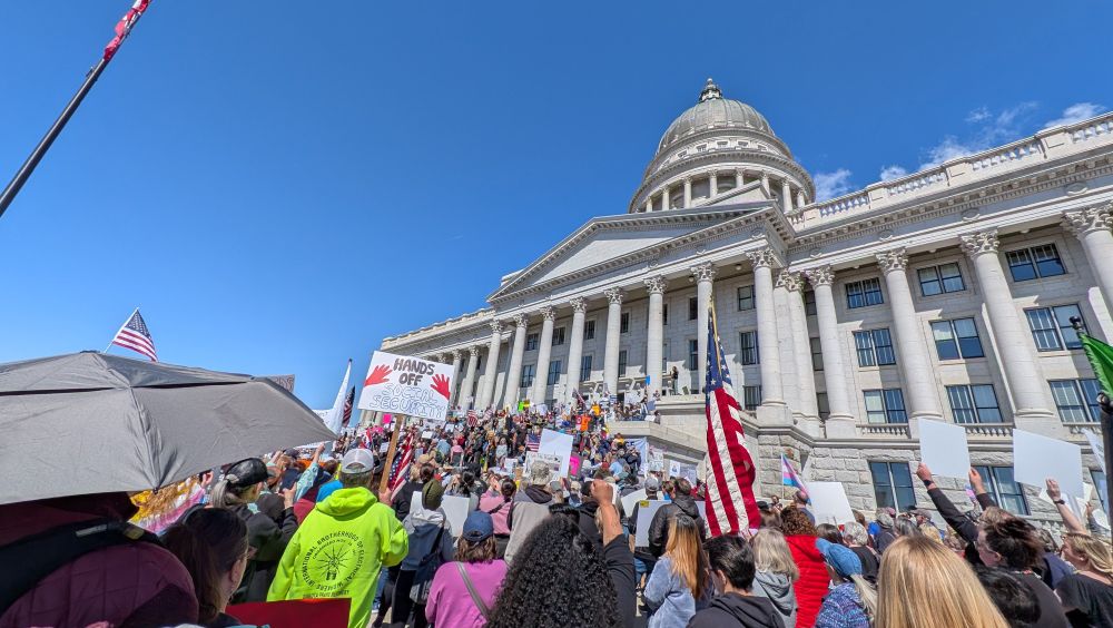 The Utah State Capitol steps flooded with people holding signs and flags while someone was speaking.