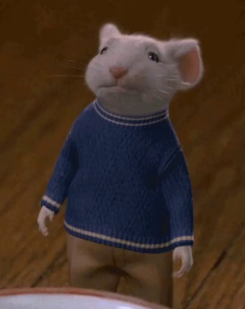 a mouse wearing a blue sweater is waving his hand