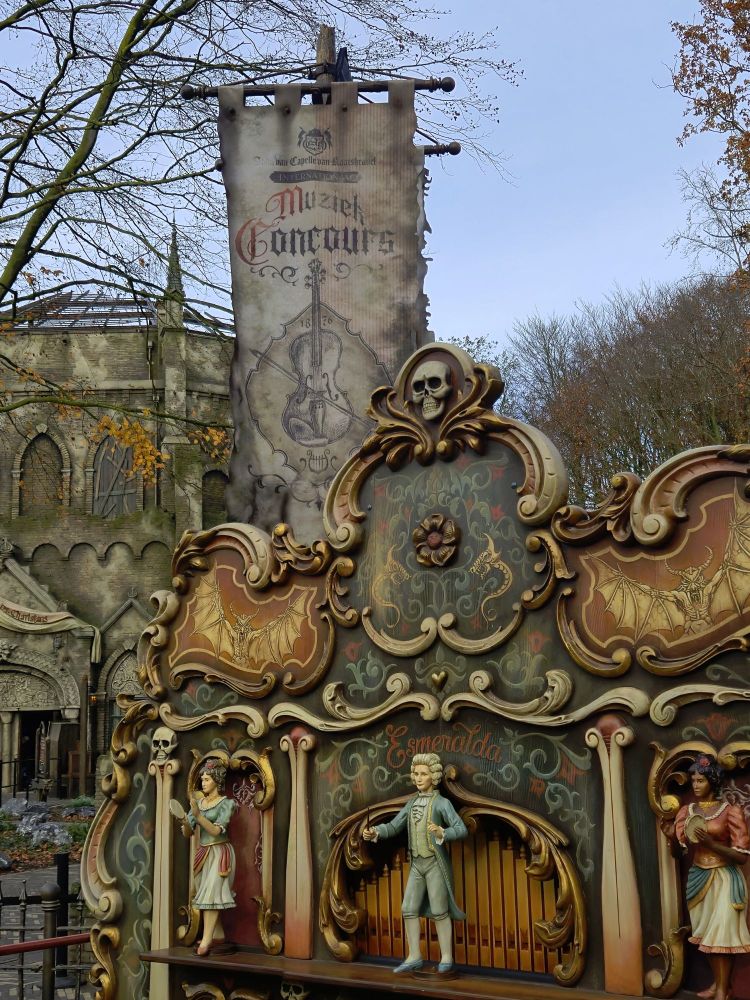 Un orgue de barbarie appartenant à la famille charlatan, il est devant le bâtiment de Danse Macabre, une grande chapelle ronde en pierre, avec un toit en bois délabré.